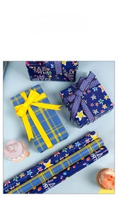 Gros plan de papier cadeau d'anniversaire avec motifs étoiles et design à carreaux bleus