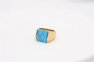 Macro detail of men's gold square titanium ring featuring inlaid blue turquoise stone
