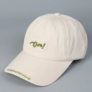 Primer plano de gorra de béisbol crema con bordado verde de letras 'On!' en 3D