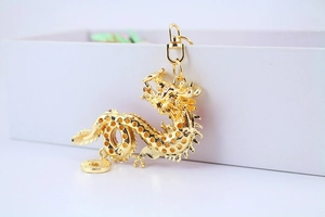 Detailed close-up of a golden dragon keychain with intricate hollowed-out metal craftsmanship