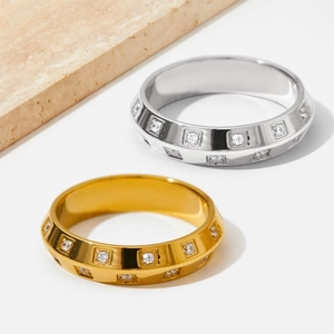 Elegant gold and silver stainless steel rings with square-set zircon stones on white surface
