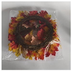 Close-up of autumn harvest wreath with artificial maple leaves and red berries in packaging