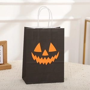 Halloween gift bag in black kraft paper with an orange pumpkin jack-o'-lantern face