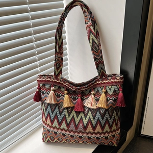 Ethnic woven tote bag with colorful geometric patterns and decorative tassels