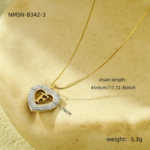 Detail shot of a heart pendant necklace with gold letter F and cubic zirconia pavé