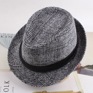 Détail d'un chapeau fedora en laine à carreaux noir et blanc avec ruban noir chic