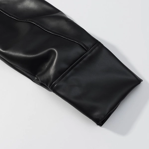 Dettaglio del polsino della giacca in pelle nera che mostra la texture PU e le cuciture fini