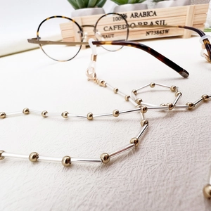 Detail of beaded glasses chain with gold beads, clear tubes, and silicone loops