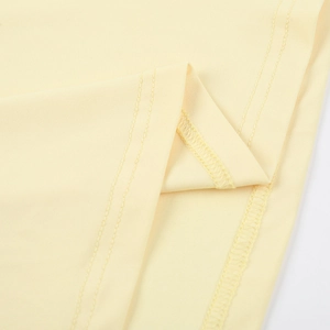Vue macro détaillée du tissu en maille jaune clair avec des coutures précises à double aiguille