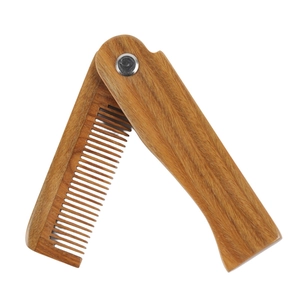 Folding green sandalwood beard comb with natural wood grain and metal hinge on white background