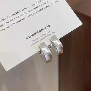 Minimalist silver matte wide wave hoop earrings with a textured brushed metal finish
