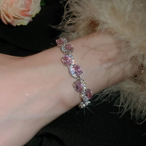 Close-up of sparkling pink oval zircon bracelet with pavé diamonds on woman's wrist
