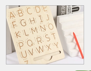 Macro detail of wooden alphabet tracing board with stroke order guides and red stylus