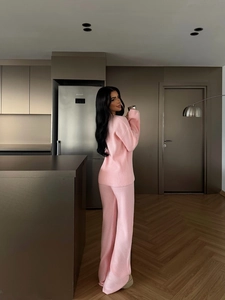 Pink two-piece knit set with long sleeve sweater and wide-leg trousers in modern home