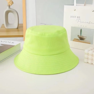 Detail of neon green cotton bucket hat with delicate embroidery on a minimalist background