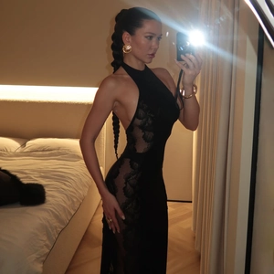 Détail de la dentelle transparente latérale sur une robe longue dos nu noire ajustée