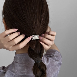 Minimalist silver hammer-textured metal hair clip worn on a low ponytail hair style