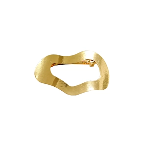 Close-up of golden wavy hollow bow hair clip showing textured metal and spring mechanism
