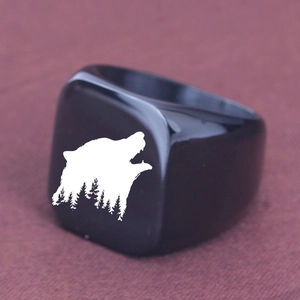 Macro side view of a black punk ring featuring a laser-engraved wolf and forest silhouette