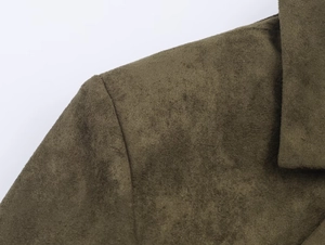 Close-up of olive green faux suede fabric and clean shoulder stitching on the blazer