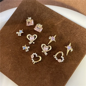 Macro view of gold heart and star studs with colorful zircon on a velvet display
