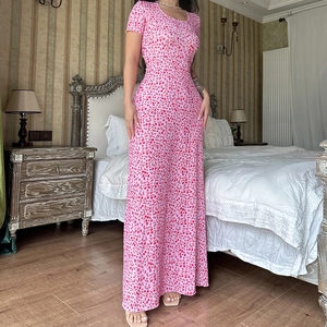 Detail eines rosa Blumenkleides mit U-Ausschnitt und kurzen Ärmeln in einem Vintage-Zimmer