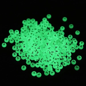 Detailed macro view of glowing green circular beads with letter Y for DIY jewelry