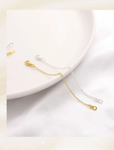 Macro detail of 14K gold and silver extender chains with lobster clasps for DIY jewelry