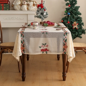 Detail of Christmas table runner with red and green embroidery on beige fabric