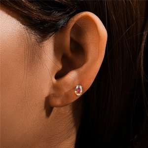 Detailed close-up of a 925 silver ear stud with moonstone and gold plating on an ear