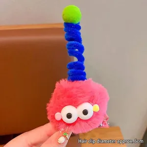 Détail macro d'une pince à cheveux monstre en peluche rose de 5cm avec de grands yeux