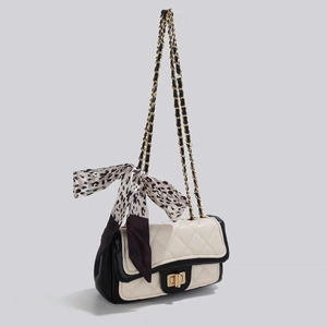 Détail du sac chaîne matelassé blanc avec foulard léopard et fermoir rotatif doré