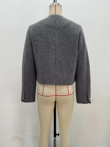 Detail view of the back of a grey wool coat showing textured fabric and short cut design