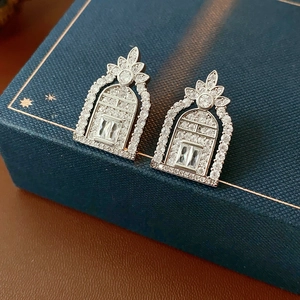 Detailed macro of silver hollow geometric oval earrings with square zircon crystals
