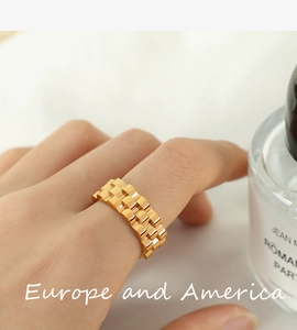 Close-up of a gold-plated stainless steel ring with a watchband chain link texture design