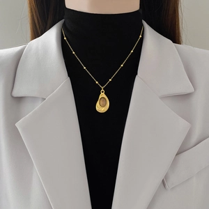 Minimalist gold titanium necklace with teardrop pendant and brown gemstone inlay