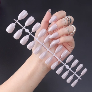 Detail of glossy light purple pointed press-on nails on a plastic display strip