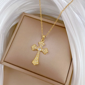 Macro shot of gold cross pendant with cubic zirconia on a luxury jewelry gift box