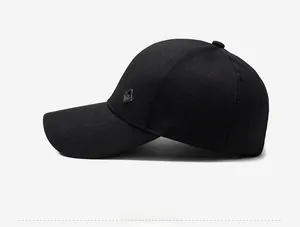 Side view detail of a black baseball cap featuring a diamond-shaped metal badge on the side