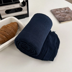 Deep blue woven meditation shawl with fringe detail shown in a cozy lifestyle setting
