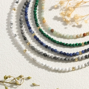 Detailed close-up of natural stone bead necklaces with elegant gold metal accents
