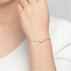 Detailed close-up of a rose gold cat paw bracelet with sparkling zircon on a woman's wrist
