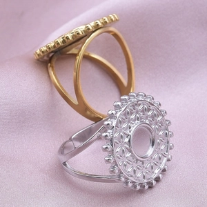 Detail of round geometric cutout rings in gold and silver finish on silk background