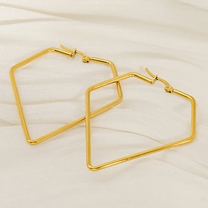 Minimalist gold geometric pentagon earrings made of stainless steel on silk background
