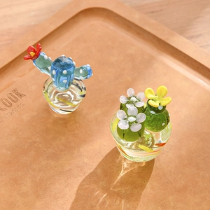 Handcrafted blue and green glass cactus figurines on a rustic wooden decorative tray