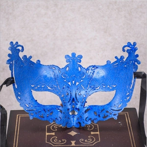 Close-up of blue glitter lace party mask with black ribbon ties on vintage box