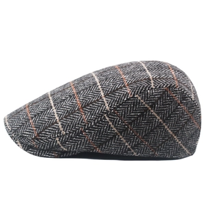 Detailed view of gray herringbone wool tweed newsboy cap with vintage plaid pattern texture