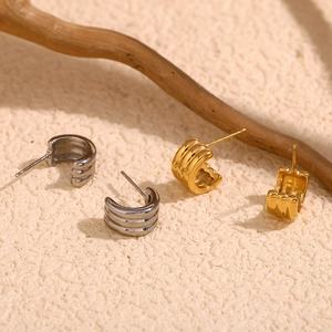Detailed macro view of triple-layered 18K gold plated textured C-shape stud earrings