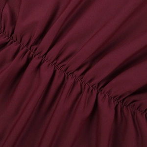 Close-up of wine red ruched stretch fabric showing detailed stitching and pleated texture