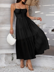 Detail of elegant black tiered maxi dress featuring a high waist and delicate straps